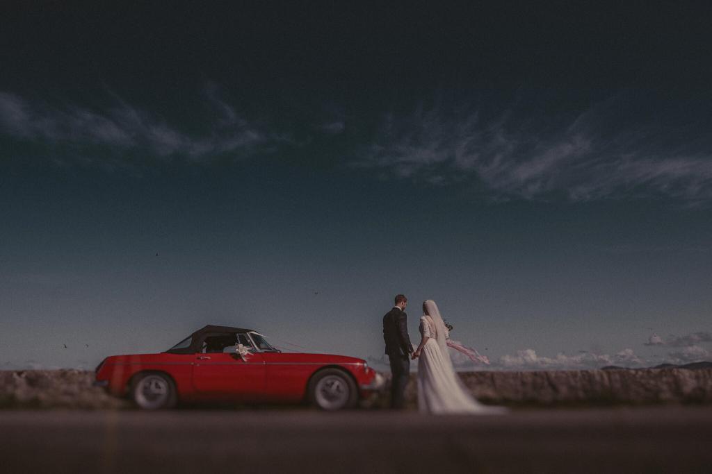 Newly weds admiring the view from the road near Beaumaris, Anglesey from an Anglesey Wedding Photographer