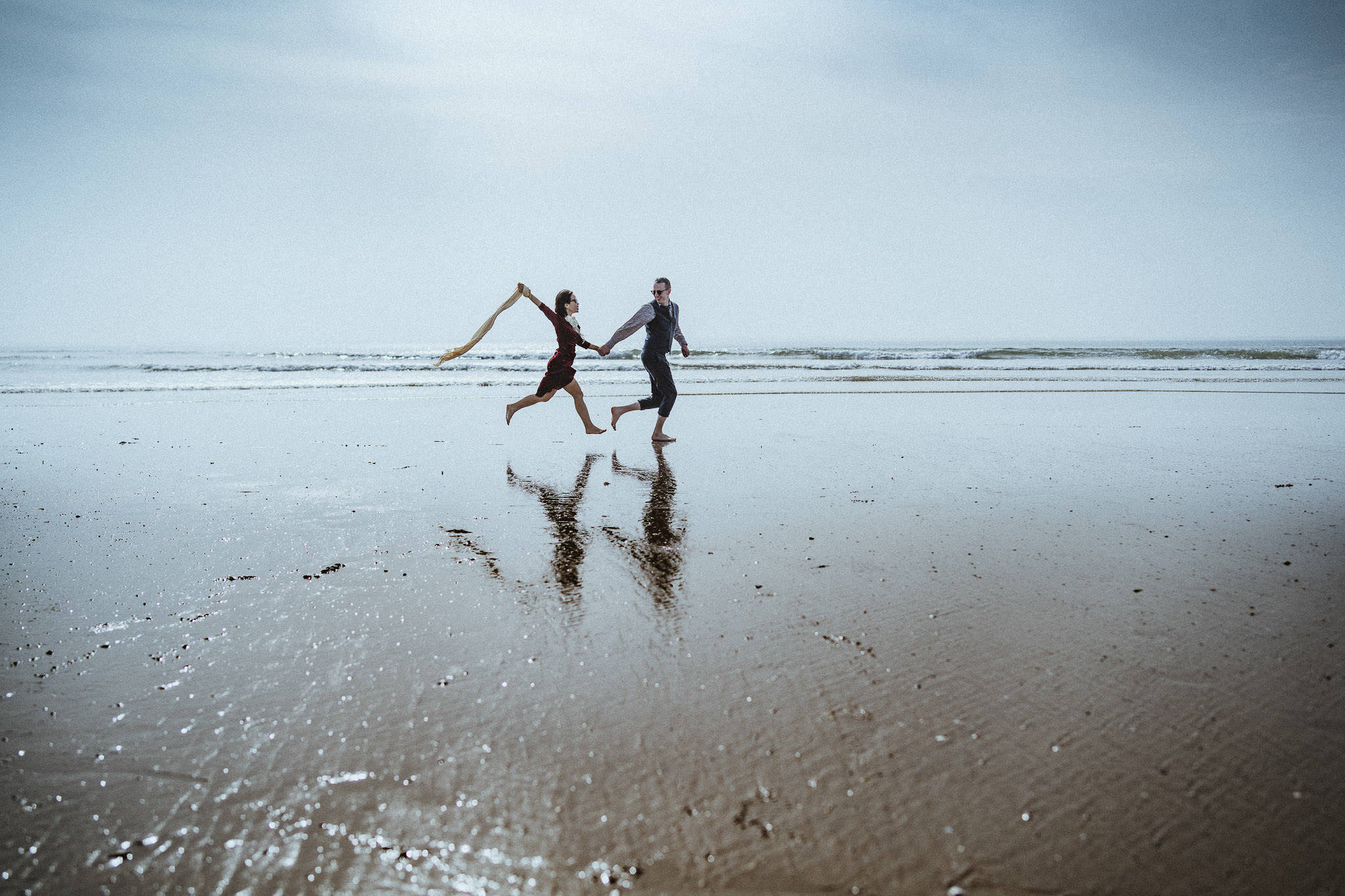 A couple running on Malltraeth Bay beach, Anglesey.